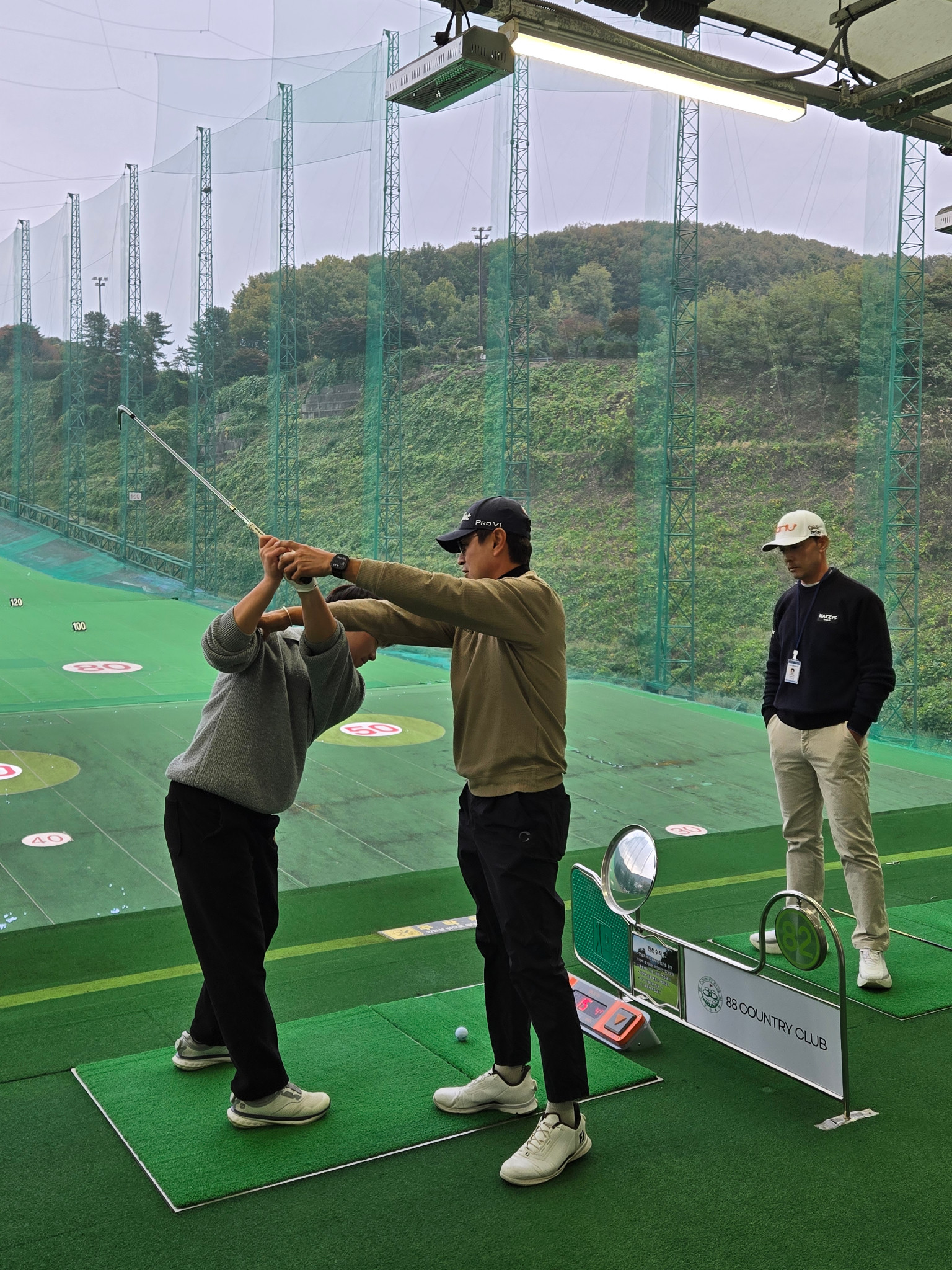 학생의 스윙을 살펴보는 지도 장면